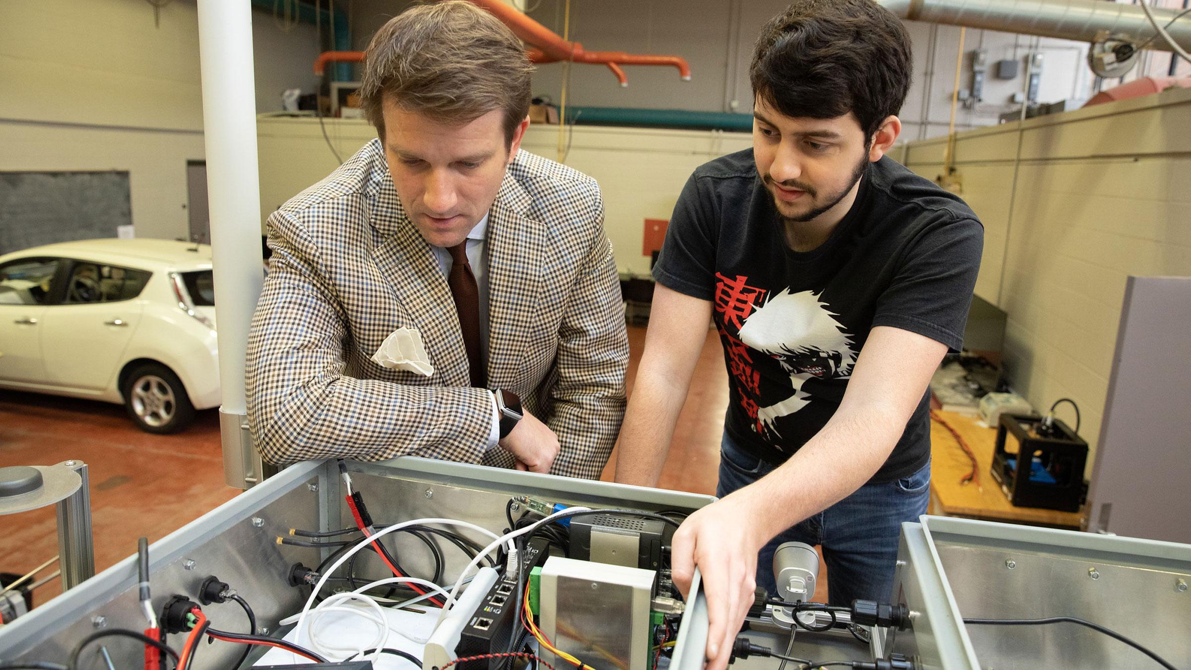 A University of Louisiana at Lafayette student and professor look at a control board while doing engineering research