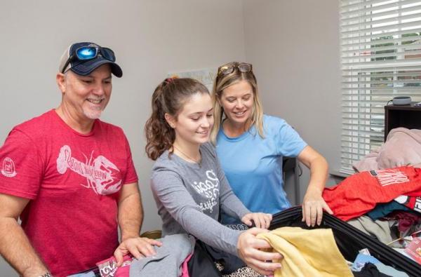 A freshman Louisiana at Lafayette student unpacking her dorm room with her parents